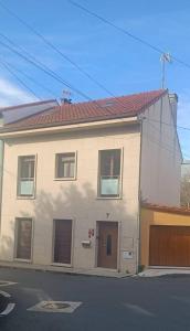 a white house with a red roof on a street at Sienna Home Apartamento in Santiago de Compostela