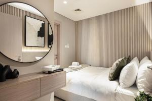 a bedroom with a bed and a large mirror at Luxury 4 Bedroom Apartment with Ferrari World and Sea Views, Yas Island Waterfront, Pool, Gym, Playground, Walk to Yas Mall in Abu Dhabi