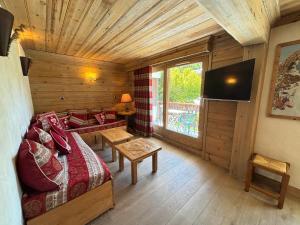a room with a bed and a television in a cabin at Appartement 3 pièces jusqu'à 6 pers, Méribel centre, proche pistes et commerces - FR-1-411-68 in Les Allues
