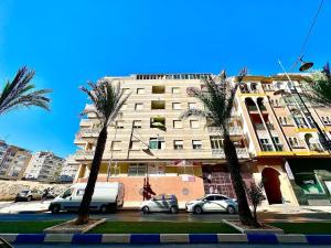 a tall building with palm trees in front of it at Alba Apartman Torrevieja in Torrevieja
