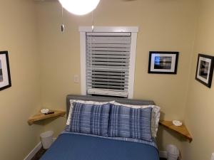 una camera da letto con un letto con lenzuola blu e una finestra di Cottage11 of Avalon -2 Bedroom-1 Bath- Laundry- Sleeps 6 a Lansing