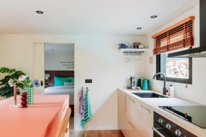 a kitchen with white counters and a sink at Bumblebee Cabin in Diessen +25 photos