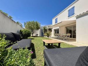 podwórko ze stołem piknikowym i domem w obiekcie Maison neuve 8 pers. avec terrasse, 600m de la plage, La Cotinière, Saint-Pierre-d'Oléron - FR-1-246A-185 w mieście Saint-Pierre-dʼOléron