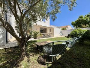 ławka siedząca obok drzewa na podwórku w obiekcie Maison neuve 8 pers. avec terrasse, 600m de la plage, La Cotinière, Saint-Pierre-d'Oléron - FR-1-246A-185 w mieście Saint-Pierre-dʼOléron