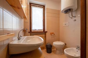 Un baño pequeño con lavabo e inodoro. en Casa Lugli by go new location, en Cavalese 16 fotos más