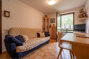 una sala de estar con un sofá y una mesa en Casa Lugli by go new location, en Cavalese