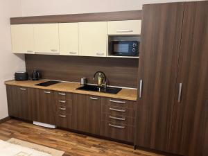 a kitchen with a sink and a microwave at RRR Apartmány 5 in Bojnice
