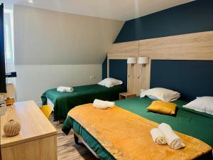 una camera d'albergo con due letti con asciugamani sopra di Armor Hotel a Compiègne
