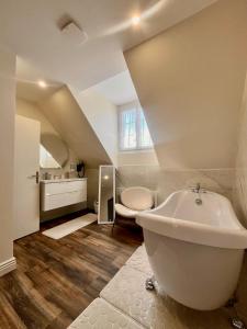 un bagno con una vasca bianca e un lavandino di Armor Hotel a Compiègne