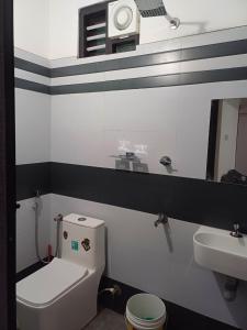a bathroom with a white toilet and a sink at Dream Stay Mukkam in Mukkam
