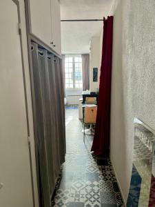 un corridoio con una tenda rossa e una stanza con un tavolo di L appartement du centre a Montauban