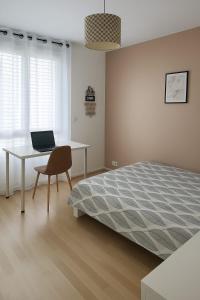 a bedroom with a bed and a desk with a laptop at Appartement spacieux de 100m2 Brest in Brest