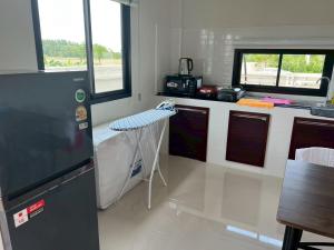 a kitchen with a table and a counter top at เคียงนา เฮ้าส์ นครพนม - KiangNa House Nakhon Phanom in Ban Noi Pho Kham