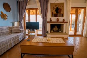 a living room with a couch and a fireplace at Helios Villa Fourka in Skala Fourkas