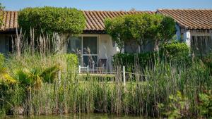 a house with tall grass in front of it at Hotel La Tramontane in Saintes-Maries-de-la-Mer