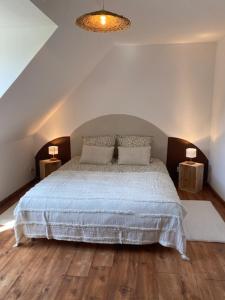 Un dormitorio con una cama grande con dos mesitas de noche. en Chambre campagne et salle de bain privée, en Le Mesnil-Guillaume