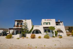 a large white building in the sand in front at Sea Melody Studios in Plaka