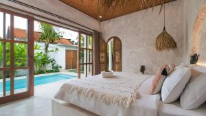 een slaapkamer met een groot bed en een zwembad bij Nick Villas by Villa Finder in Ubud