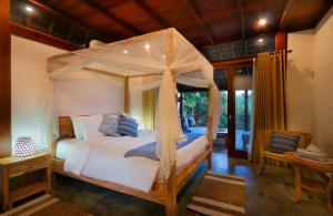 un dormitorio con una cama con dosel en Kaloi Villa, en Bedahulu 26 fotos más