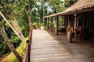 una pasarela de madera que conduce a una cabaña en el bosque en Kaloi Villa, en Bedahulu