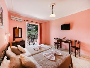 a bedroom with two beds and a table and a desk at Sunrise studios Lefkada in Nydri