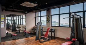 a gym with treadmills and exercise equipment and windows at Wanderlust Retreat Studio by Iconic Regency in Bayan Lepas