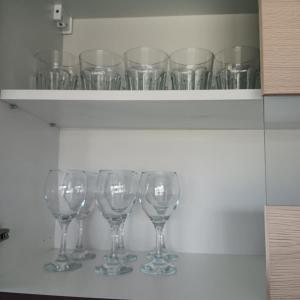 a row of wine glasses sitting on a shelf at Valva vila in Luokesos Sen
