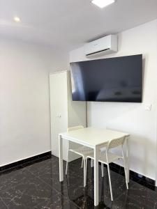 a white table with two chairs and a tv on a wall at SL Marbella in Marbella