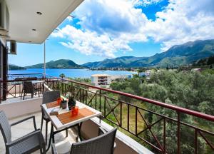 a balcony with a table and chairs and a view of the water at Sunrise studios Lefkada in Nydri