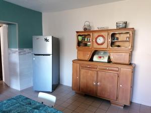 a kitchen with a refrigerator and a small cabinet at La lolavane in Montigny-sur-Crécy