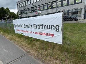 a sign on a fence next to a building at Aparthotel Emilia in Bargteheide