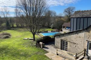 CléguérecにあるGites Les Hibouxの庭にスイミングプールがある家