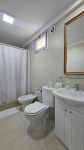 a white bathroom with a toilet and a sink at Del Santo San Rafael in Puerto Madryn +30 photos
