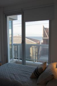 Un dormitorio con un gran ventanal con vista al mar. en Del Santo San Rafael, en Puerto Madryn