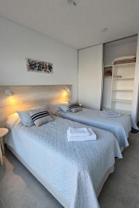 a bedroom with two beds with towels on them at Del Santo San Rafael in Puerto Madryn