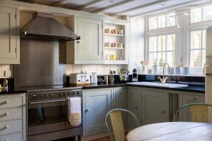 a kitchen with white cabinets and a stove top oven at Fern House in Dorchester