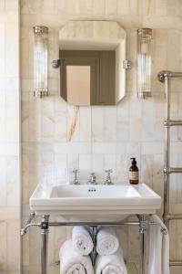 Un baño con lavabo, espejo y toallas. en Fern House, en Dorchester