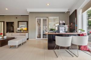 a living room with a counter and white chairs at White Waters Hotel in Machico
