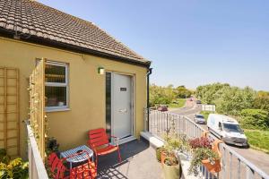 a balcony of a house with red chairs and a car at Host & Stay - Lewes Road Apartments in Newhaven