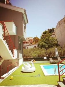 a backyard with a pool with a swan float next to a house at MGE Luxury house with pool in Iraklitsa