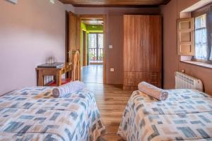 ein Schlafzimmer mit zwei Betten und einem Schreibtisch und einem Tisch in der Unterkunft Casa Rural En Picos De Europa in Labra