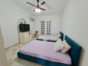 une chambre avec deux lits et un ventilateur de plafond dans l'établissement فيلا مارينا 2, à El Alamein 11 autres photos