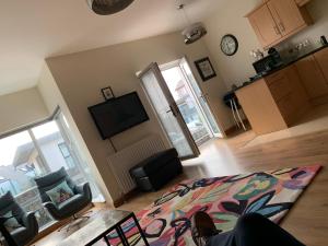 a living room with a couch and a tv at Pennisula Apartment in Portrush +3 photos