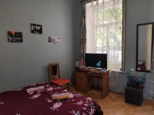 a bedroom with a bed and a desk and a window at apartment Jessi on Marjanishvili in Tbilisi City