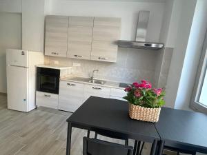 a kitchen with a black table with flowers on it at B&B Domo Mia in Nuoro
