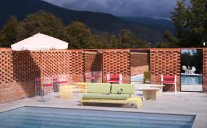 a patio with a couch and chairs next to a pool at Hotel Chateau Kvareli in Kvareli