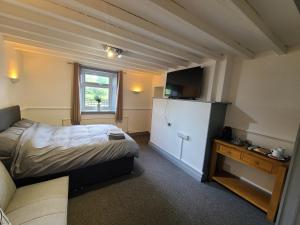 a small bedroom with a bed and a refrigerator at Oakwood Airport Accommodation in Lulsgate Bottom