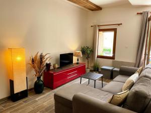 a living room with a couch and a tv at Gîte à Oisly près des Châteaux de la Loire avec Parking et Animaux Bienvenus - FR-1-491-469 in Oisly