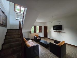 a living room with couches and a tv on the wall at Finca Hotel Galilea Doradal in Doradal