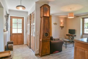 ein Wohnzimmer mit einer Großvater-Uhr und einer Couch in der Unterkunft La Maison Dauphinoise in Saint-Bueil